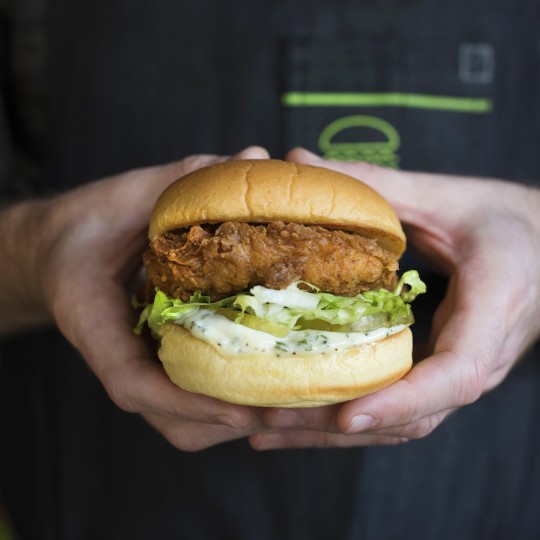 The Chick’n Shack, Shake Shack’s debut chicken sandwich being held with two hands