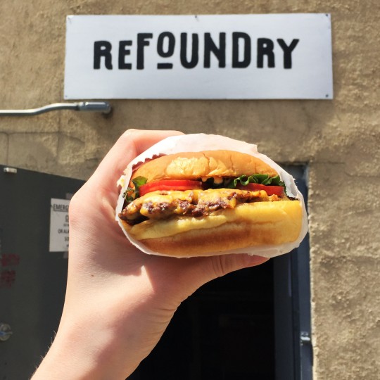 Shake Shack burger in front of Refoundry sign