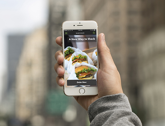 hand holding an iPhone displaying the Shake Shack App