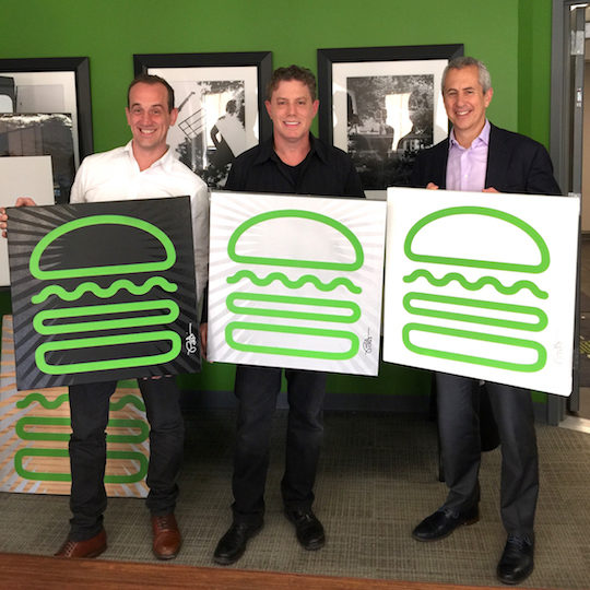 burton morris and two other men holding enlarged shake shack icons