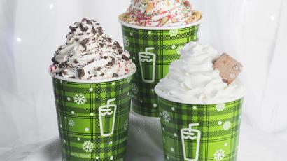 three shakes with different toppings, in green holiday themed cups