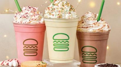 three shakes with green straws sticking out. There are fairy lights behind them, and cookies in front.