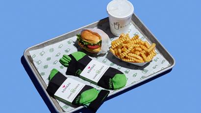 shake, fries, burger, and two pair of Bombas branded socks sitting on a tray.