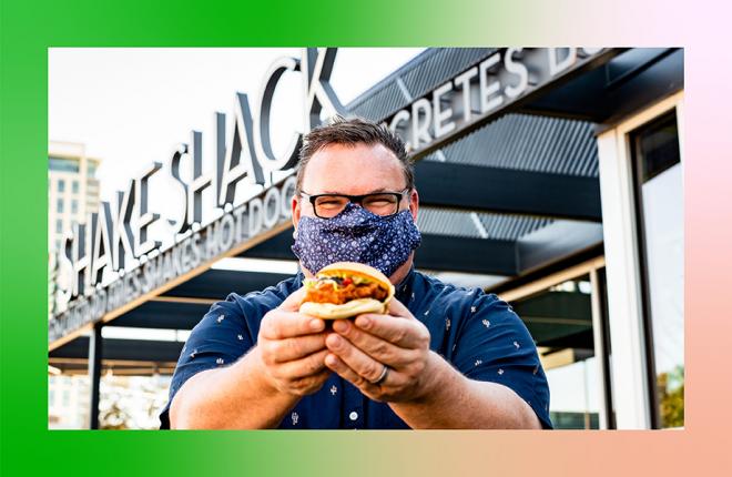 Chris Shepherd holding a sandwich outside of Shake Shack