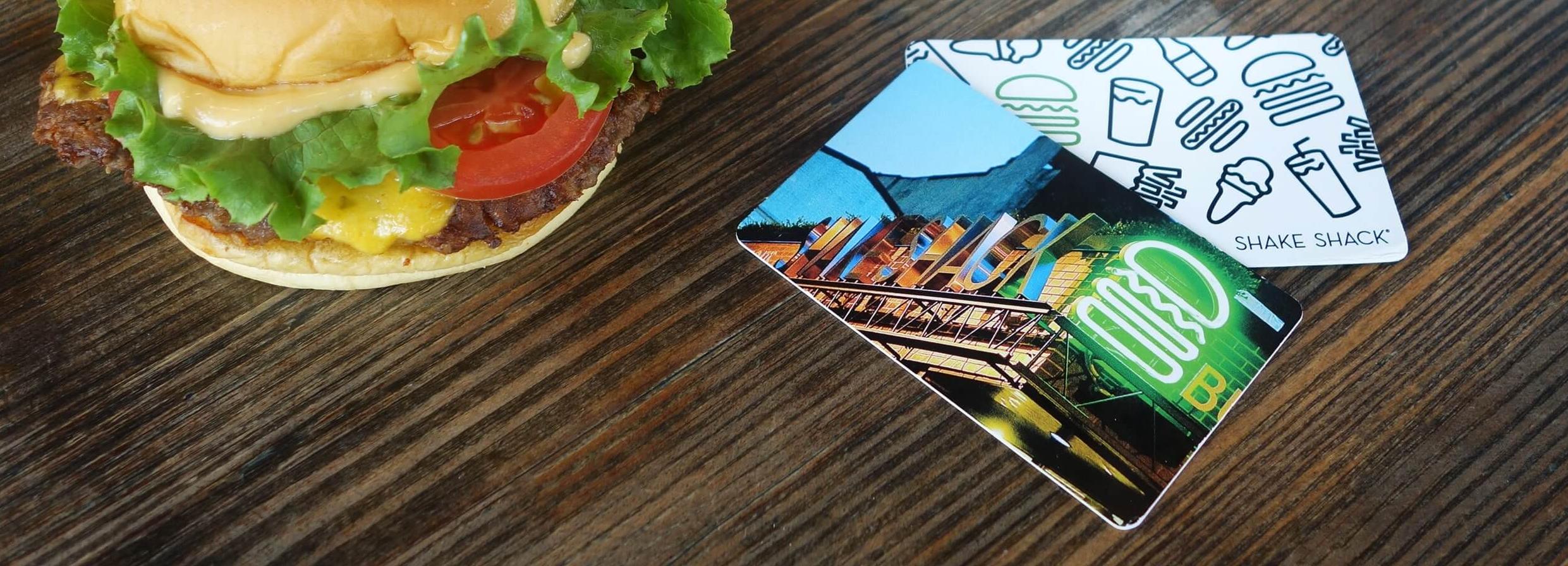 Burger on a table with gift cards next to it